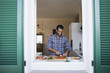 © michela ravasio/Stocksy - Smiling man preparing a vegetarian dish