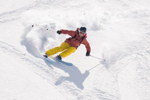 Man Skiing With  Speed Downhill Ski Slope Splattering The Snow