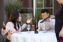 Couple On A Date Angry At A Waitress In An Outdoor Restaurant.  They Are Upset And Dissatisfied With The Customer Service Or The Food In The Cafe.  The Image Depicts The Food And Service Industry.