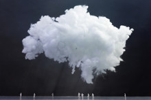 View Of White Fluffy Clouds Above A Group Of Tiny People