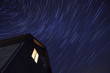 © Cosma Andrei/Stocksy - Low angle view of star trail over the house at night