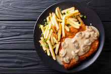 Delicious Wiener Hunter Schnitzel With Sauce And French Fries Close-up. Horizontal Top View