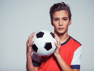 Wall Mural - Photo of teen boy in sportswear holding soccer ball