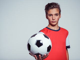 Wall Mural - Photo of teen boy in sportswear holding soccer ball