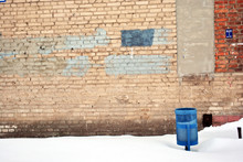 Blue Trashcan In Snow On The Old Red Brick Wall Background