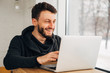 © newagecinema - Happy young bearded student keeping his hands on keyboard of generic laptop computer while working on diploma project