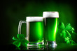 St. Patrick's Day. Green beer pint over dark green background, decorated with shamrock leaves. Traditional Irish festival
