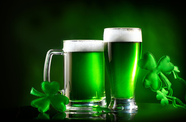 Wall Mural - St. Patrick's Day. Green beer pint over dark green background, decorated with shamrock leaves. Traditional Irish festival