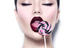 © Subbotina Anna - Sexy beauty girl eating lollipop. Glamour model woman licking sweet colorful lollipop candy over white background