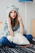 © mashiki - young beautiful woman relaxing at home on the bed, wearing funny grey hoodie. Waking up in lazy weekend morning