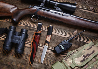 Hunting rifle and ammunition on a wooden background.