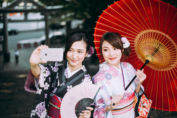 Wall Mural - Two japanese girls wearing kimonos traditional clothes, lifestyle moments