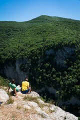 Two friends sits on the top of rock sunny day