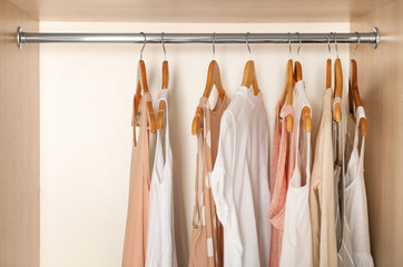 Wall Mural - Hangers with different clothes in wardrobe closet