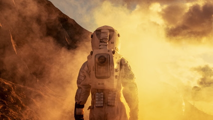 Wall Mural - courageous astronaut in the space suit explores red planet mars covered in mist. adventure. space tr