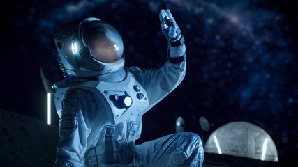 Wall Mural - astronaut is looking at recently found rock sample on the alien planet. space travel and exploration