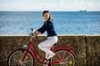 © Jacek Chabraszewski - Young woman riding bike on pier