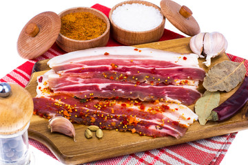 Poster - Slices of smoked bacon with light on wooden kitchen cutting board