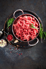 Wall Mural - Cooking mince. Raw ground veal meat with ingredients for cooking on black kitchen table. Fresh minced meat, top view