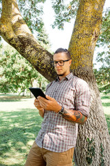 Poster - Guy using tablet pc in summer park.