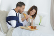 young couple eating the breakfast on the bed