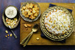 Arabic cuisine; Jordanian Chicken Mansaf of white rice and crispy fried bread topped with chunks of chicken,toasted almond and garlic yogurt sauce on copper plate.Top view