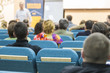© danmorgan12 - Male Presenter Holding a Conference In Front of a Group of Listeneres. in a Congress Hall.