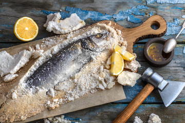 Wall Mural - Fish baked in salt with lemon and oil, top view