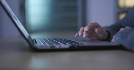 Woman working on laptop computer at night