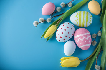 Wall Mural - Colorful Easter eggs with yellow Tulip hand painted on a blue background. Holiday spring card