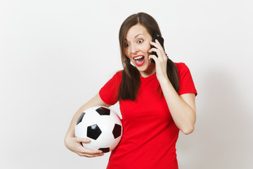 Wall Mural - European young angry screaming woman, football fan or player in yellow uniform talk on mobile phone, hold soccer ball isolated on white background. Sport, play football, healthy lifestyle concept.