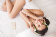 top view of a pretty young woman listening to earphones. Cheerful beautiful girl smiling. Lady resting indoors