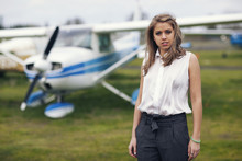 Young Woman In Front Of Prop Plane Getting Ready To Travel
