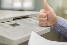 Close-up Of A Hand Of A Young Office Manager With A Finger Up On A Multifunction Printer Or Copier
