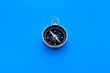 Compass on blue background top view copy space