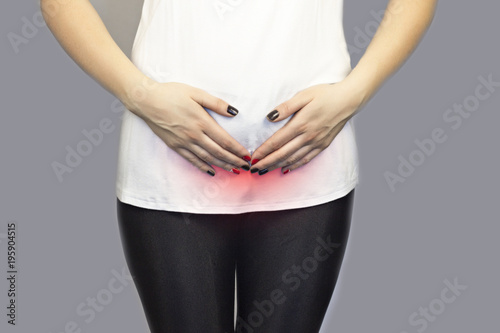 Fotografia, Obraz .The girl holds on to the bottom of the abdomen, the lower abdomen is red, the m