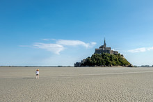 Girl Walking In The Bay Of  Mont Saint-Michel At Low Tide