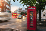 Fototapeta Londyn - a view of the iconic red telephone box in London with moving cars in the background