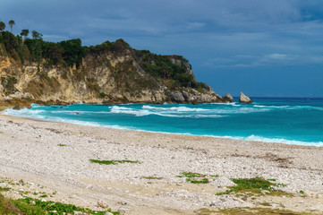 Wall Mural - Ideal Caribbean empty beach with azure sea and green rocks