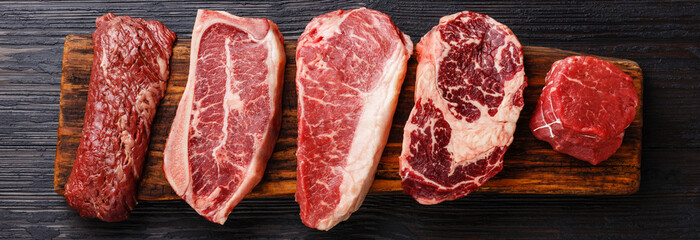 variety of raw black angus prime meat steaks machete, blade on bone, striploin, rib eye, tenderloin 