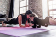 © undrey - Mother and daughter working out together doing plank exercise in sports club