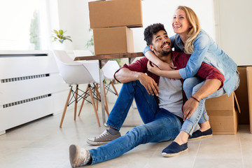 Wall Mural - Young couple unpacking cardboard boxes at new home moving in concept