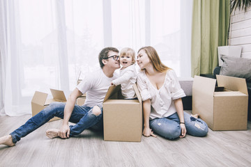 Wall Mural - Family together happy young beautiful with a little baby moves with boxes to a new home