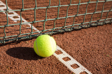 tennis ball with line and net on a sand court