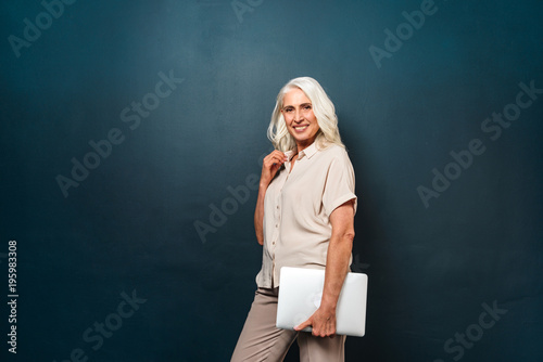 Cheerful Mature Old Woman Holding Laptop Computer Buy This