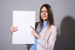 © kanzefar - Young smiling woman pointing at a blank white sheet