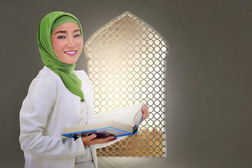 Wall Mural - Young asian muslim woman with Koran