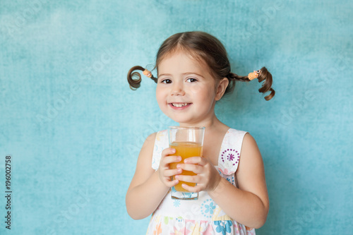 Fotografia, Obraz Smiling girl with funny pigtails with glass of juice
