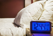 Electronic Alarm Clock Stands On A Bedside Table In The Room Or Hotel Room