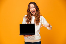 Surprised Happy Woman In Sweater Showing Blank Laptop Computer Screen